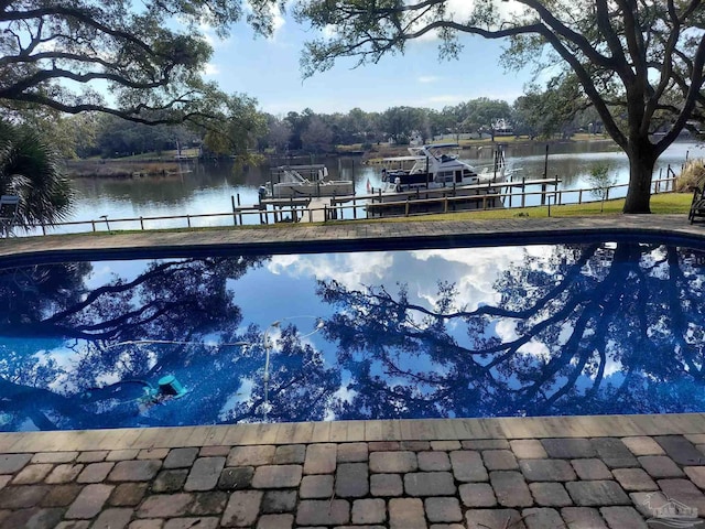 view of pool with a water view and a dock