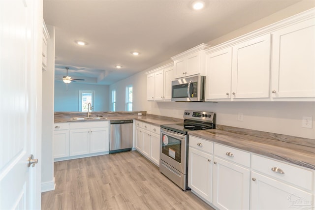 kitchen featuring white cabinets, ceiling fan, sink, and stainless steel appliances