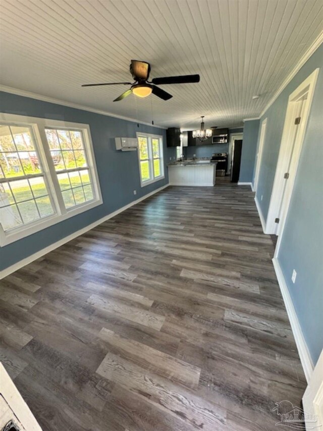 unfurnished living room with ornamental molding, a wealth of natural light, ceiling fan with notable chandelier, and hardwood / wood-style floors