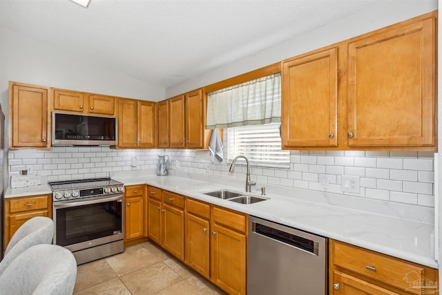 kitchen featuring decorative backsplash, appliances with stainless steel finishes, vaulted ceiling, sink, and light tile patterned floors