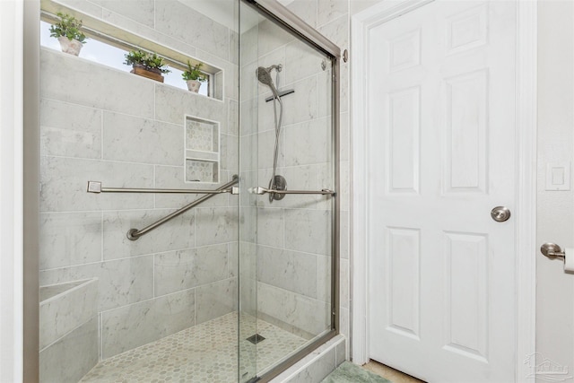 bathroom with a shower with door