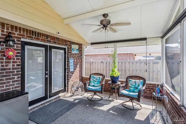 sunroom with ceiling fan and lofted ceiling with beams