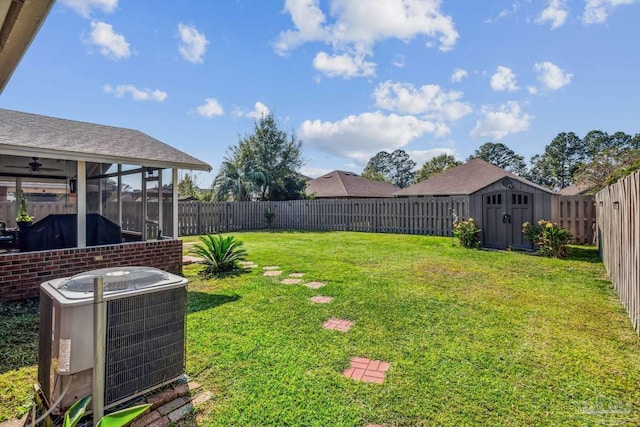 view of yard featuring a sunroom, cooling unit, and a shed