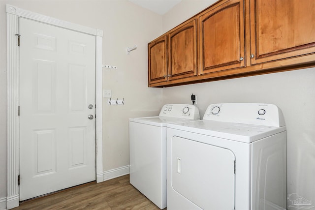 4121 Castle Gate Dr, Pace, FL 32571 - laundry room with cabinet space, washer and dryer, light wood-style flooring, and baseboards