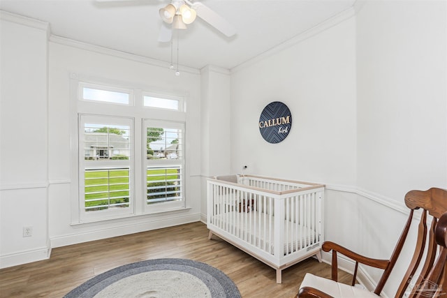 4121 Castle Gate Dr, Pace, FL 32571 - bedroom with crown molding, wood finished floors, a crib, and baseboards