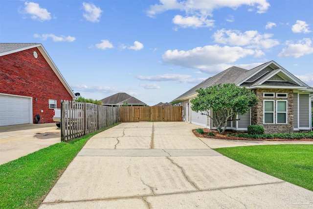 4121 Castle Gate Dr, Pace, FL 32571 - view of side of home featuring concrete driveway, stone siding, and roof with shingles