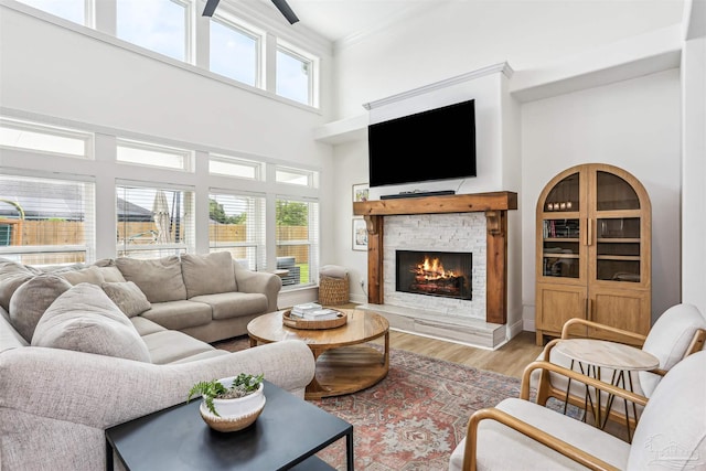 4121 Castle Gate Dr, Pace, FL 32571 - living area featuring a stone fireplace, a high ceiling, light wood-type flooring, plenty of natural light, and ornamental molding