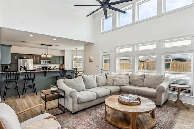 4121 Castle Gate Dr, Pace, FL 32571 - living room featuring light wood finished floors, ceiling fan, recessed lighting, a towering ceiling, and ornamental molding