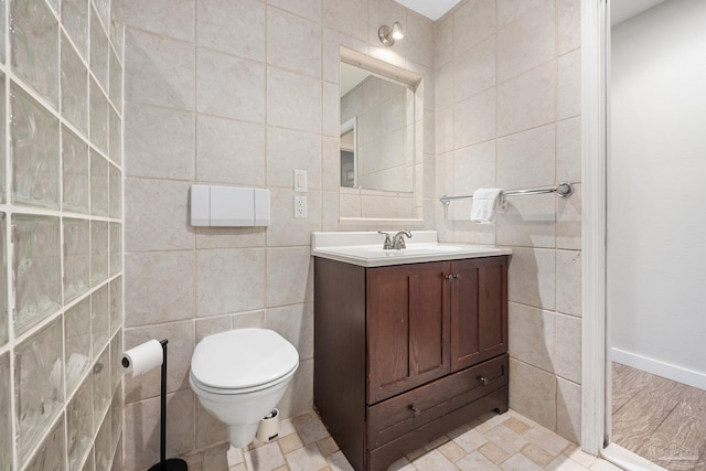 bathroom with tile walls, vanity, and toilet