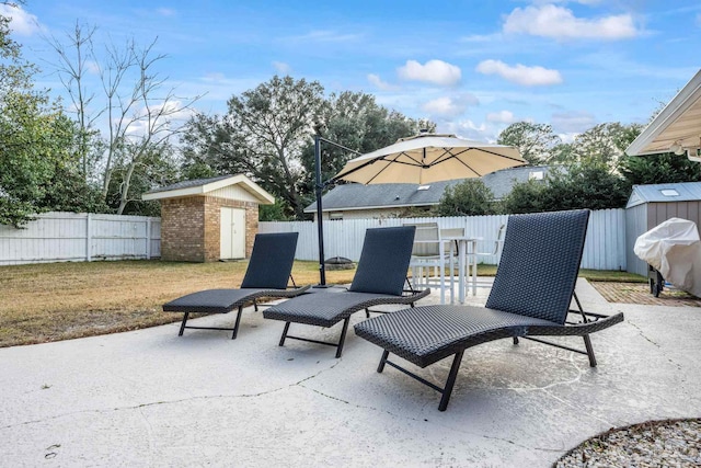 view of patio featuring a grill and a storage shed