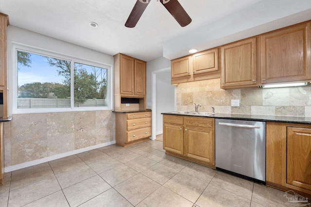 kitchen with sink, backsplash, light tile patterned flooring, dark stone counters, and stainless steel dishwasher