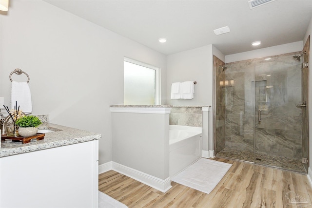 bathroom featuring vanity, wood-type flooring, and shower with separate bathtub