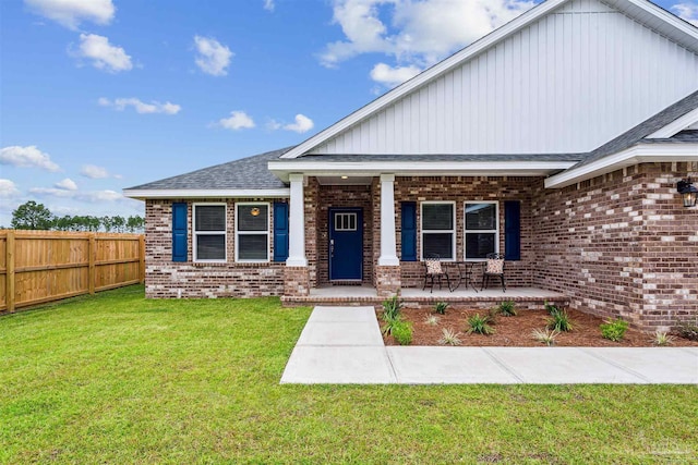 view of front of house featuring covered porch and a front yard