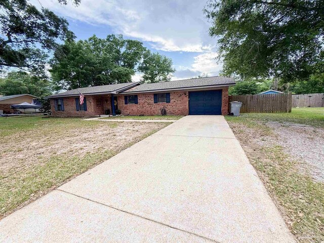 4755 Easter St, Pace, FL 32571 - ranch-style home with fence, an attached garage, brick siding, a front yard, and concrete driveway