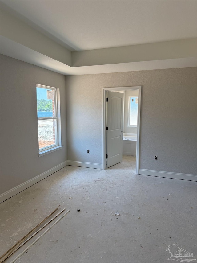 unfurnished room with baseboards