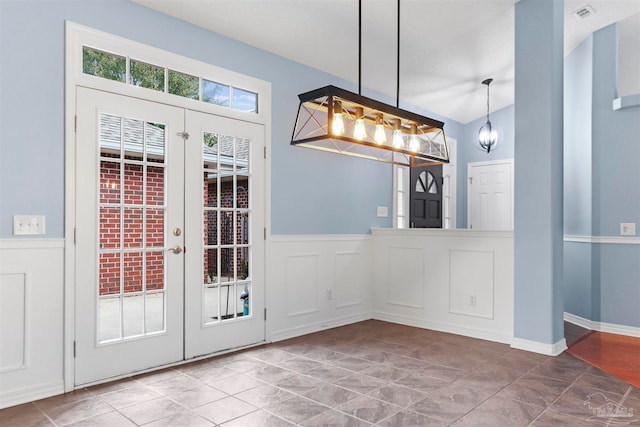 doorway featuring tile patterned floors, a chandelier, and a textured ceiling