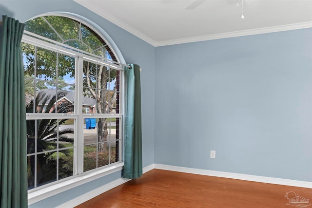 spare room featuring hardwood / wood-style floors, ceiling fan, a healthy amount of sunlight, and crown molding