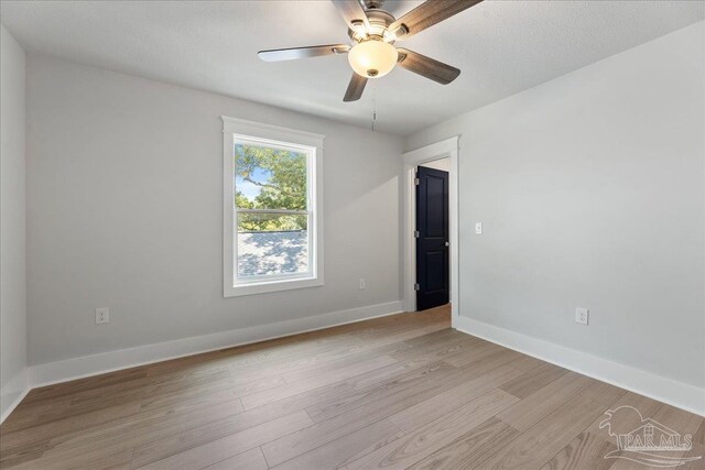 spare room with light wood-type flooring and ceiling fan