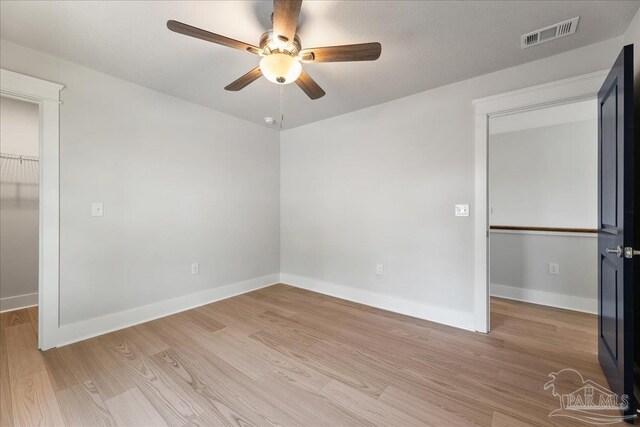 unfurnished bedroom with light hardwood / wood-style flooring, a closet, and ceiling fan