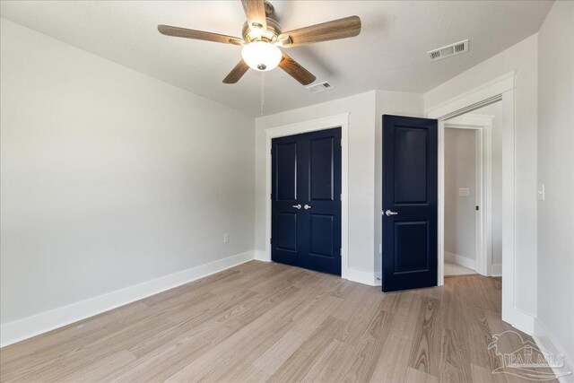 unfurnished bedroom featuring ceiling fan, light hardwood / wood-style flooring, and a closet