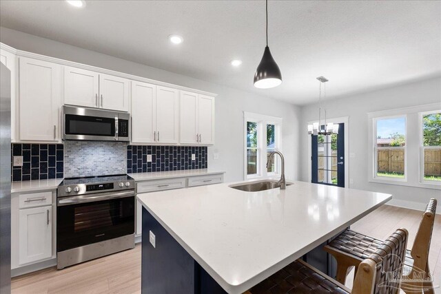 dining space with a notable chandelier, sink, and light hardwood / wood-style flooring