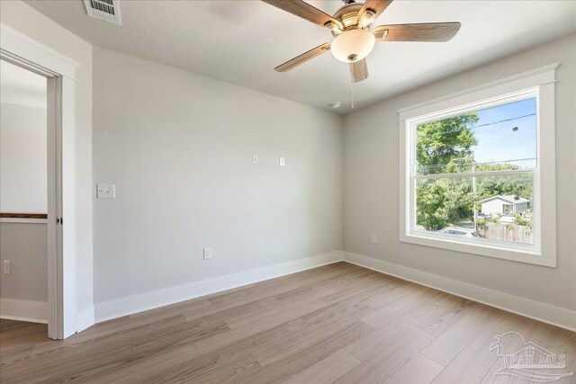 empty room featuring light hardwood / wood-style flooring, a textured ceiling, and ceiling fan