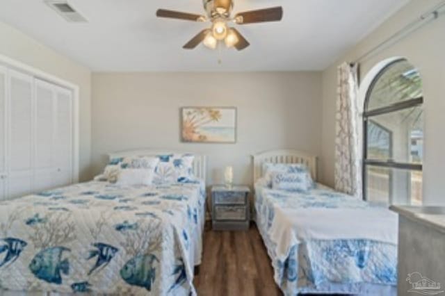 bedroom with ceiling fan, visible vents, a closet, and wood finished floors