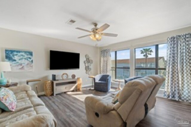 living area featuring wood finished floors, ceiling fan, and visible vents