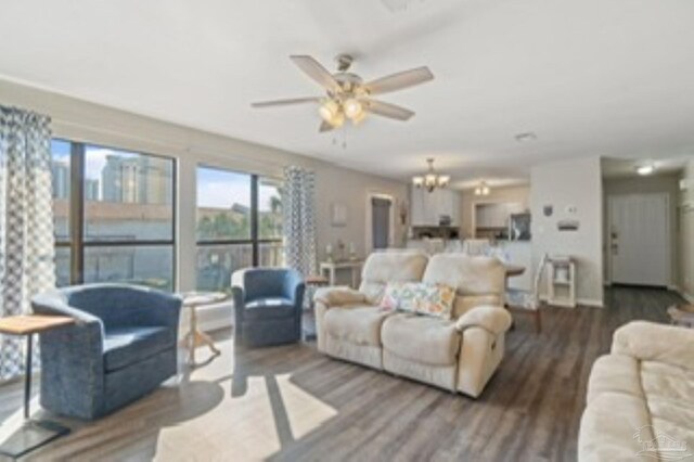living area featuring wood finished floors and ceiling fan with notable chandelier