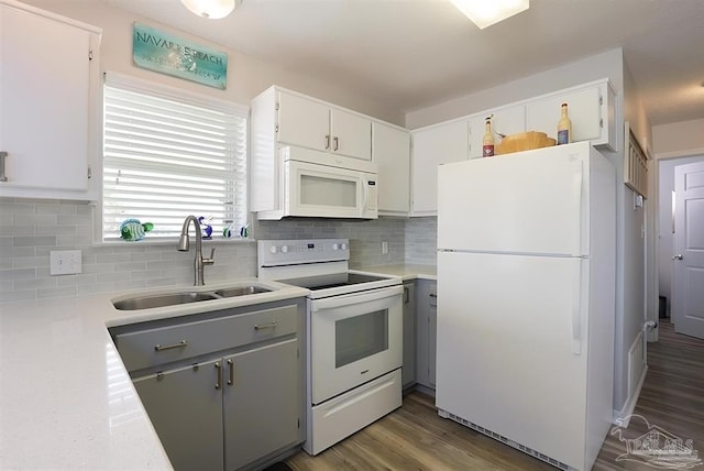 7464 Sunset Harbor Dr Unit 133, Navarre Beach, FL 32566 - kitchen featuring tasteful backsplash, white cabinetry, sink, dark wood-type flooring, and white appliances