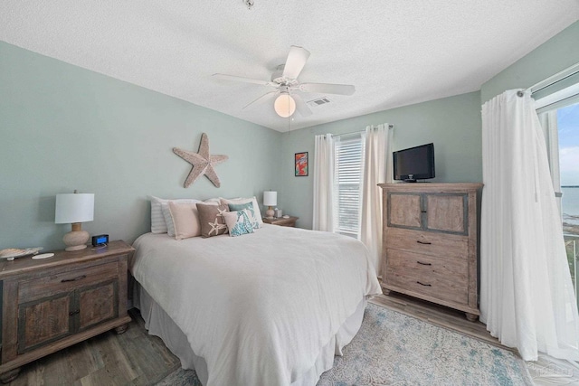 7464 Sunset Harbor Dr Unit 133, Navarre Beach, FL 32566 - bedroom with ceiling fan, a textured ceiling, and light wood-type flooring