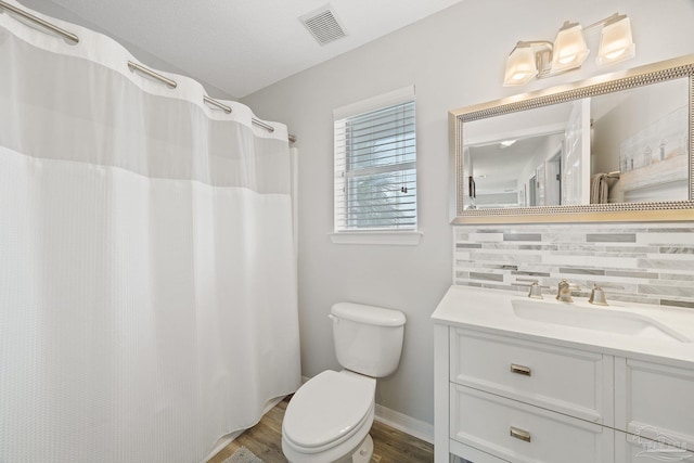 7464 Sunset Harbor Dr Unit 133, Navarre Beach, FL 32566 - bathroom with tasteful backsplash, wood-type flooring, vanity, toilet, and a shower with shower curtain