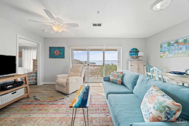 7464 Sunset Harbor Dr Unit 133, Navarre Beach, FL 32566 - living room featuring wood-type flooring, ceiling fan, and a textured ceiling