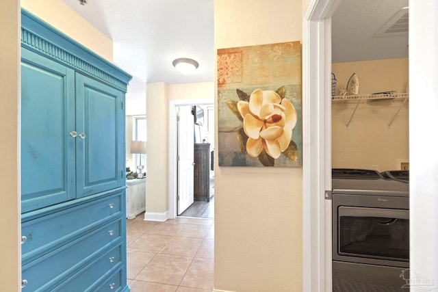 hallway featuring washer and clothes dryer and light tile patterned floors