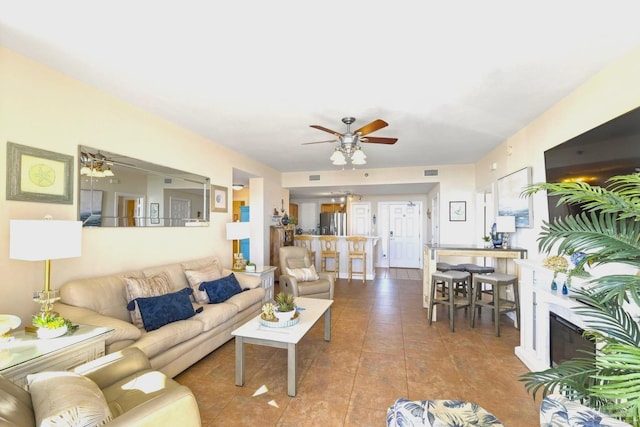 living room featuring ceiling fan and tile patterned floors