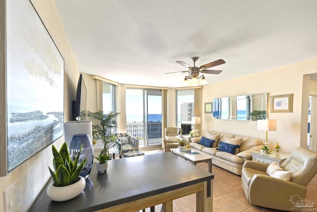 tiled living room featuring ceiling fan, a wealth of natural light, and floor to ceiling windows