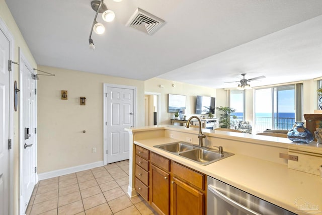 kitchen featuring stainless steel dishwasher, light tile patterned floors, ceiling fan, and sink