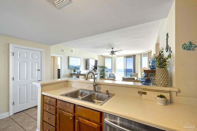 kitchen with ceiling fan, dishwasher, kitchen peninsula, sink, and light tile patterned floors