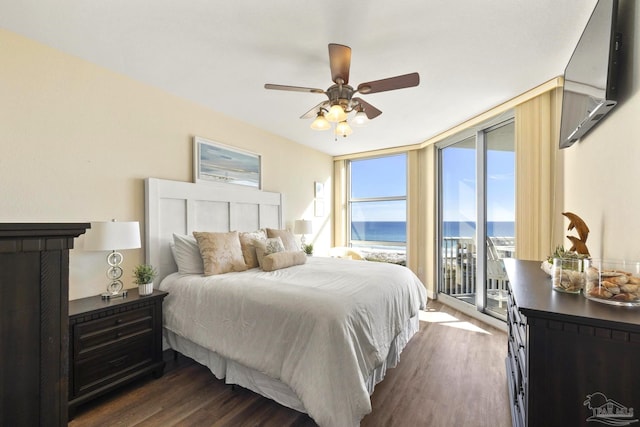 bedroom with ceiling fan, access to outside, dark hardwood / wood-style flooring, a water view, and expansive windows