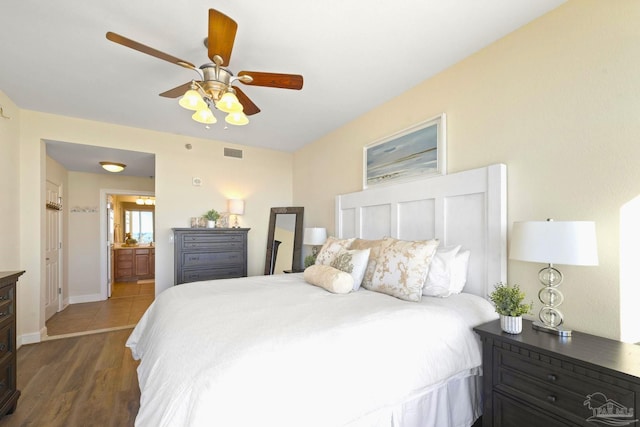 bedroom featuring ceiling fan, dark hardwood / wood-style flooring, and ensuite bathroom