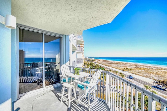 balcony featuring a water view and a beach view