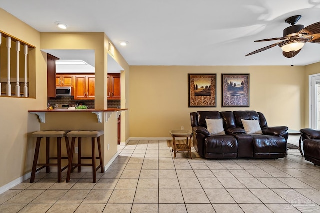 tiled living room with ceiling fan