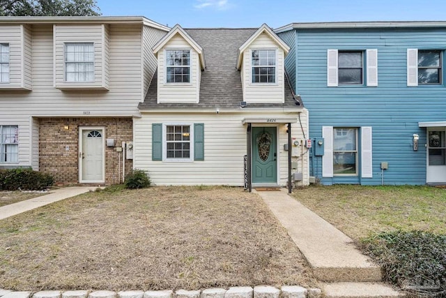 townhome / multi-family property with a front lawn