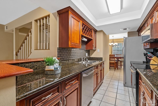 kitchen featuring sink, light tile patterned floors, stainless steel appliances, a notable chandelier, and decorative backsplash