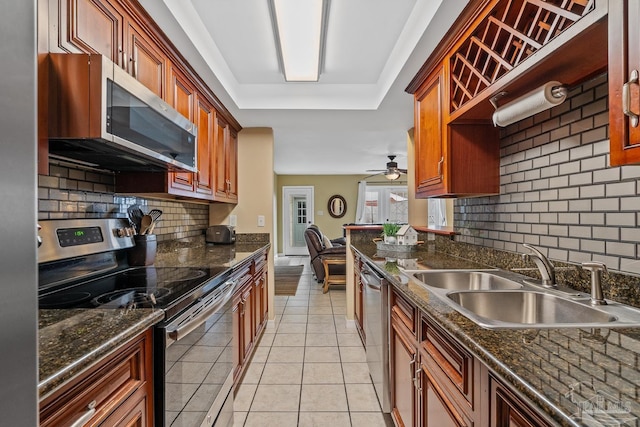 kitchen with light tile patterned flooring, appliances with stainless steel finishes, sink, and tasteful backsplash