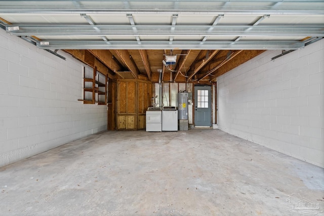 garage featuring washing machine and clothes dryer and electric water heater