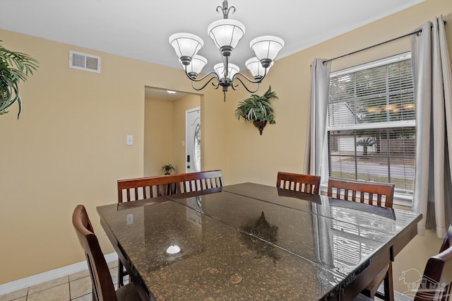 dining area with light tile patterned floors and an inviting chandelier