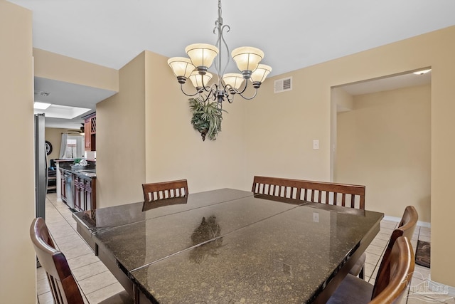 tiled dining space featuring a chandelier