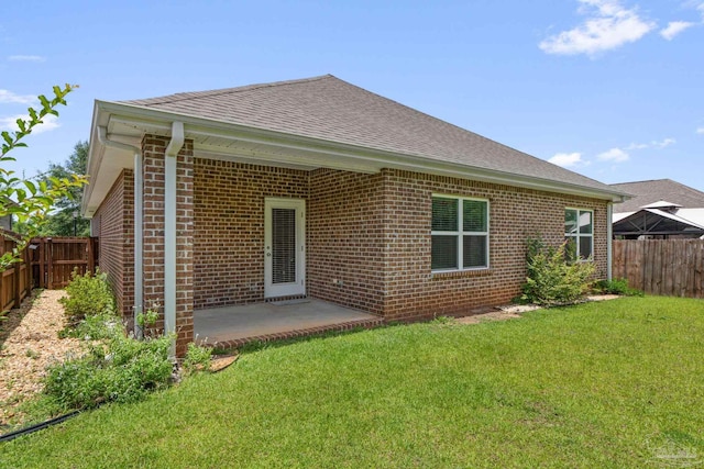 3594 Whitetail Ln, Pensacola, FL 32526 - rear view of house with roof with shingles, brick siding, a fenced backyard, and a patio