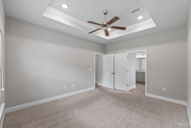3594 Whitetail Ln, Pensacola, FL 32526 - unfurnished bedroom featuring a tray ceiling, light carpet, crown molding, ensuite bath, and recessed lighting